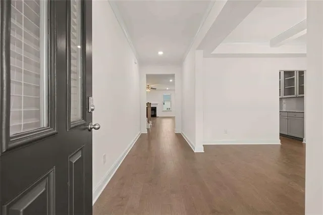 a view of a hallway with wooden floor and closet