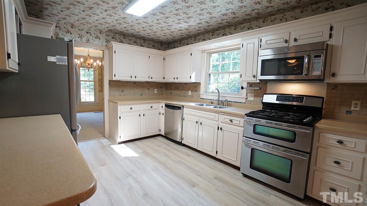 1421 Lynn Road Raleigh, NC 27612 - Photo 8 of 30 SS Appliances, gas cooktop, double oven, kitchen has had several updates over the years. New LTV floors, appliances-open to family room, so many possibilities