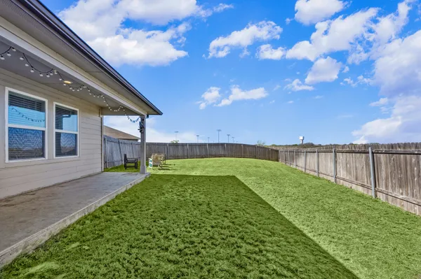a backyard of a house with table and chairs