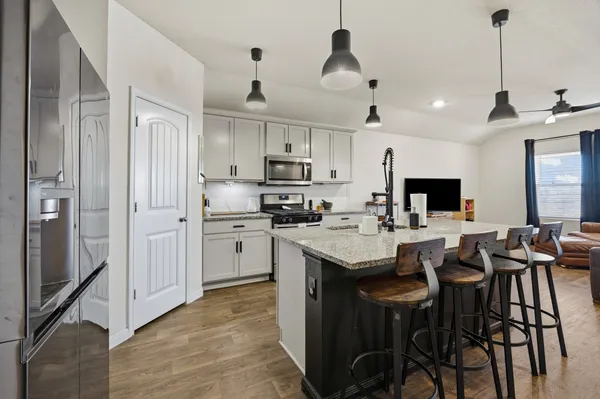 a view of a dining room and livingroom with furniture wooden floor a chandelier