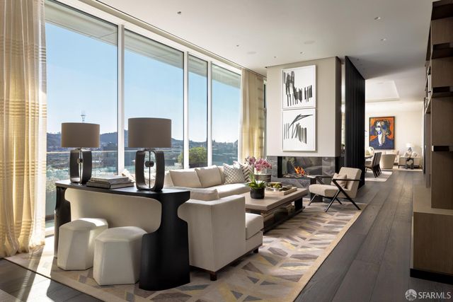 a living room with fireplace furniture and two windows