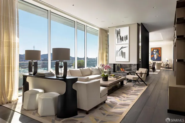 a living room with fireplace furniture and two windows