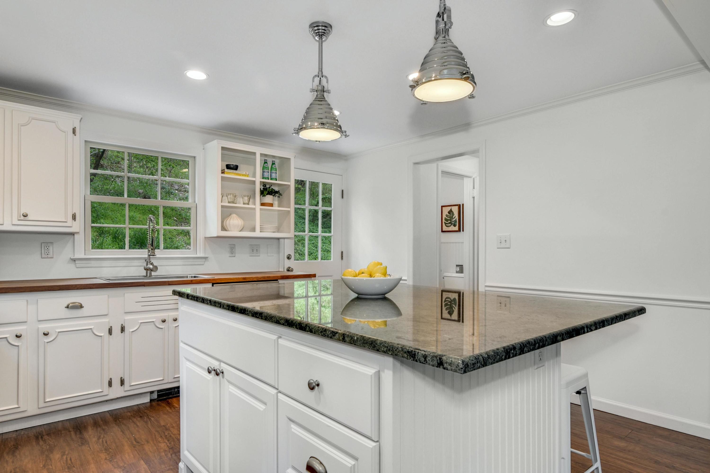 212 Tokeneke Road Darien, CT 06820 - Photo 10 of 23 a kitchen with a sink a center island cabinets and a window