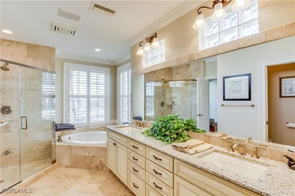 a spacious bathroom with a granite countertop tub shower sink and mirror