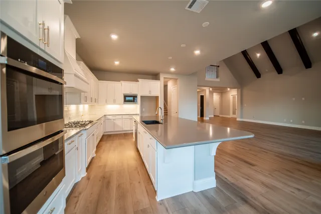 a view of a kitchen with a sink and dishwasher with wooden floor