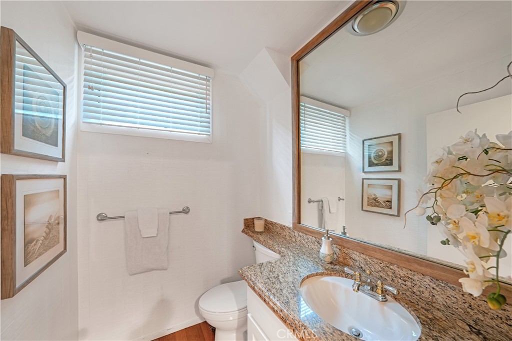 72-B Surfside Avenue Surfside, CA 90743 - Photo 34 of 56 a bathroom with a granite countertop sink toilet a mirror and shower