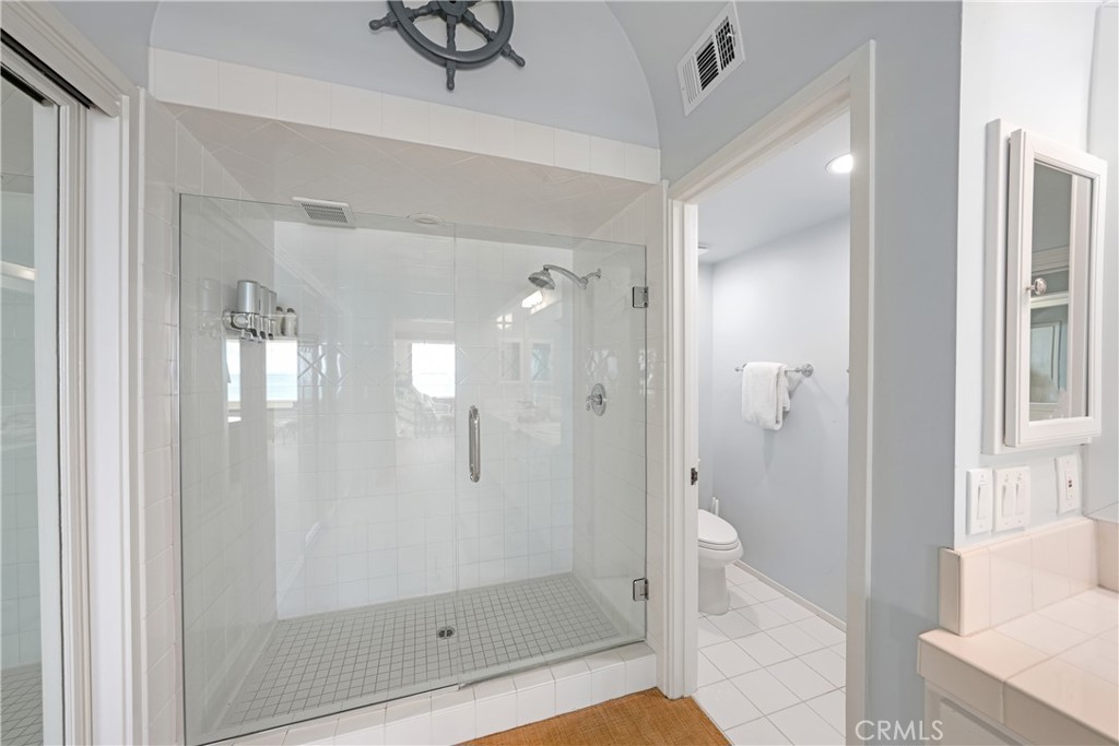 72-B Surfside Avenue Surfside, CA 90743 - Photo 41 of 56 a bathroom with a glass shower door and a bathtub