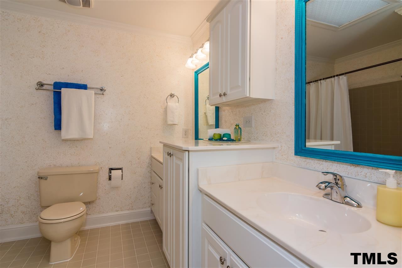 912 Queensferry Road Cary, NC 27511 - Photo 17 of 25 Hall bath on upper level with dual vanity, tiled floors and shower.