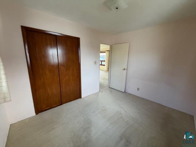 50 Beech Circle Babbitt, MN 55706 - Photo 11 of 24 Interior room featuring a built-in closet with double wood-finish doors, neutral wall paint, and light-toned carpet flooring