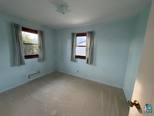 50 Beech Circle Babbitt, MN 55706 - Photo 12 of 24 Room featuring two windows with wood trim, ceiling-mounted light fixture, and carpeted flooring