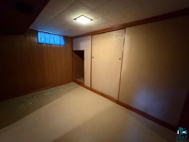 50 Beech Circle Babbitt, MN 55706 - Photo 18 of 24 Basement area featuring wood paneling, drop ceiling, and painted concrete flooring