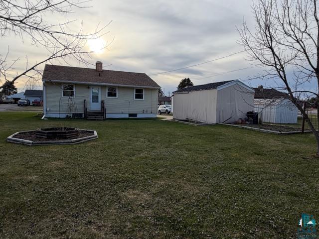50 Beech Circle Babbitt, MN 55706 - Photo 20 of 24 Expansive backyard featuring a manicured lawn, a hexagonal raised garden bed, and a detached storage shed
