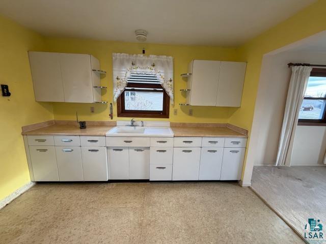 50 Beech Circle Babbitt, MN 55706 - Photo 3 of 24 Kitchen featuring a white porcelain sink, light-toned countertops, and white cabinetry with metal hardware