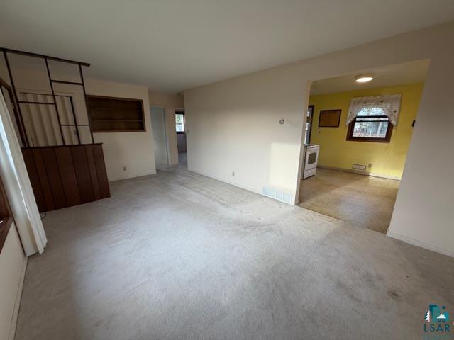 50 Beech Circle Babbitt, MN 55706 - Photo 7 of 24 Carpeted living area featuring a decorative wood-panel room divider and built-in shelving