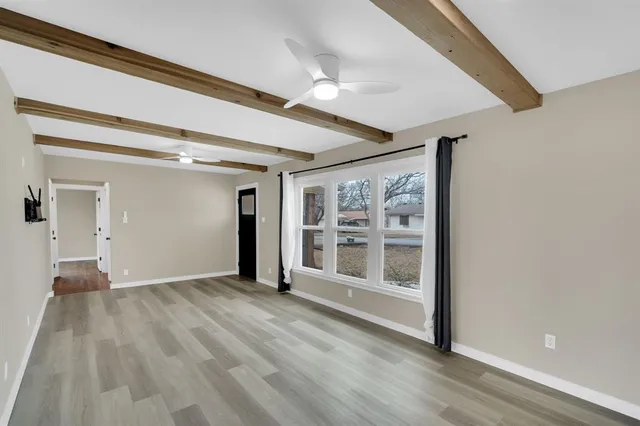 a view of a big room with wooden floor and windows