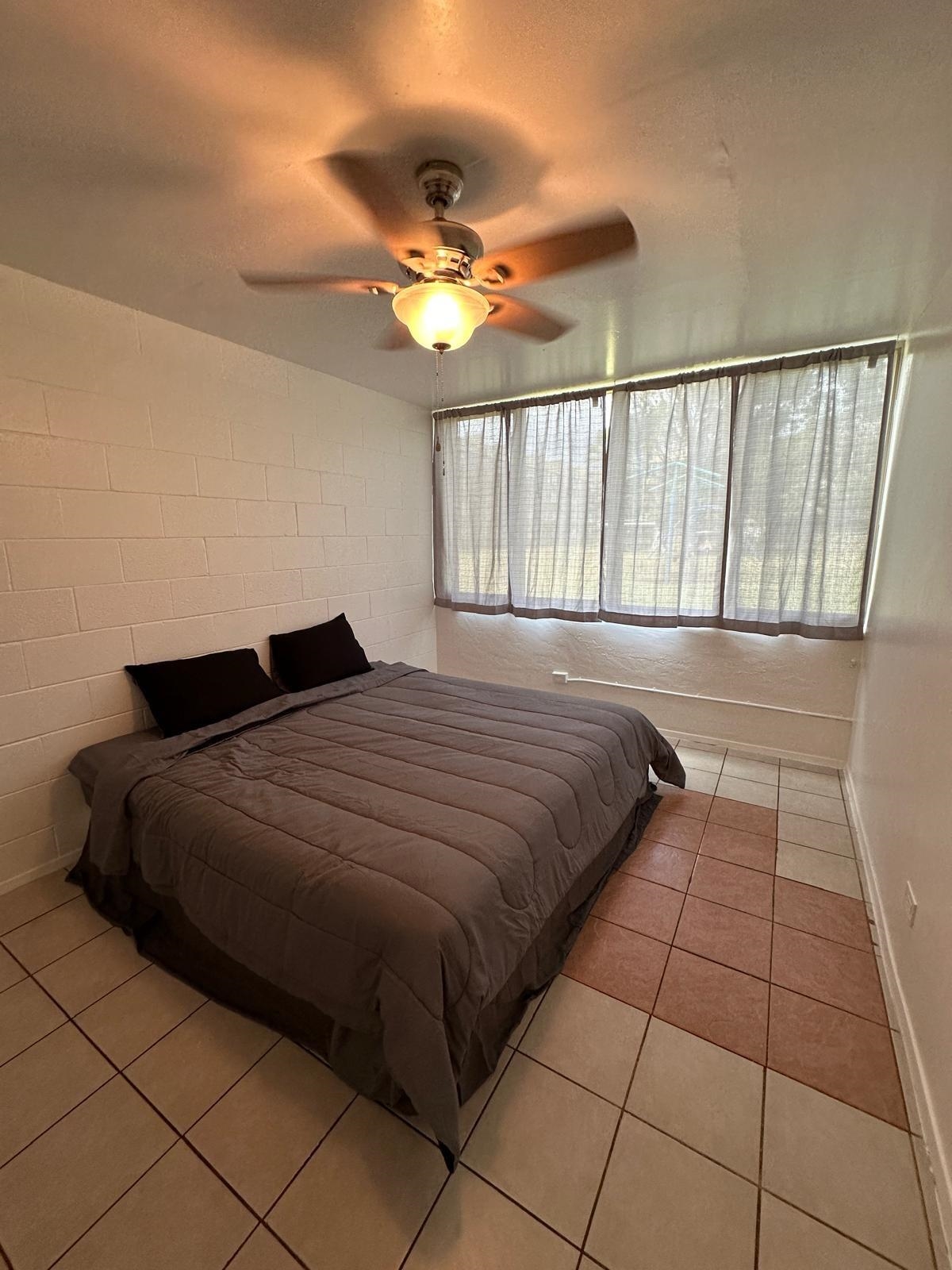 111 Kahului Beach Road, Unit C116 Kahului, HI 96732 - Photo 6 of 14 a bedroom with a bed and a chandelier