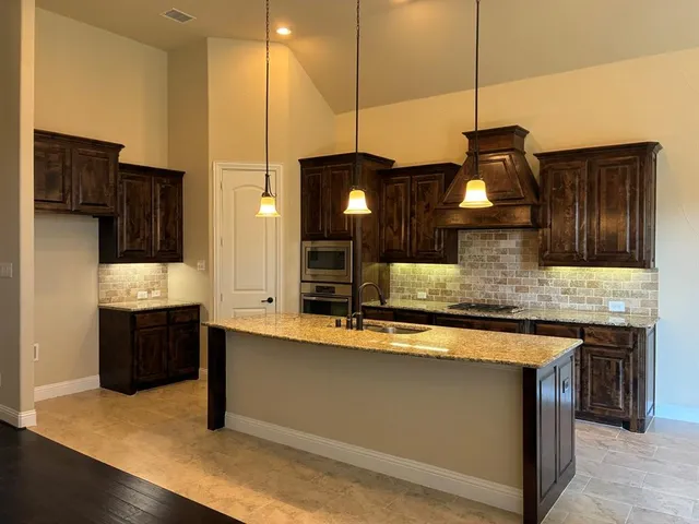 a kitchen with a sink a counter space appliances and cabinets