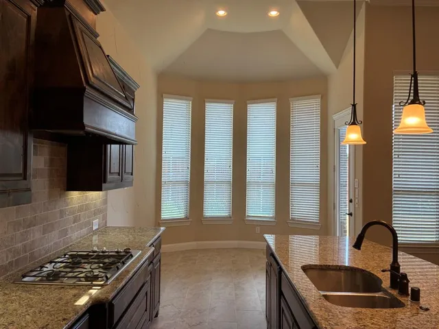 a kitchen with granite countertop a stove and a sink