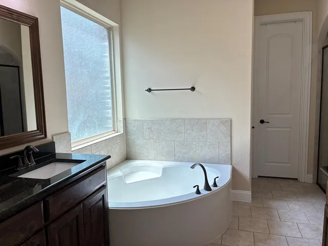a bath tub sitting in a bathroom next to a sink