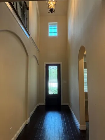a view of a hallway with wooden floor and a window