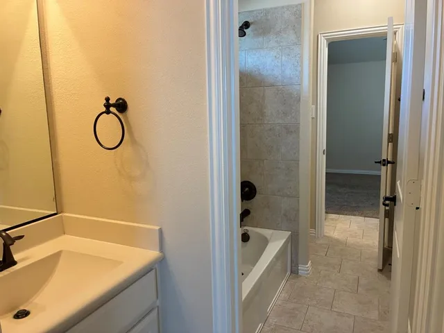 a bathroom with a tub sink and mirror