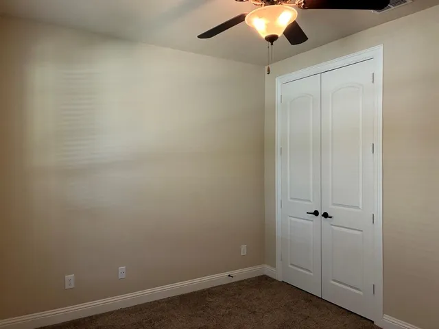 an empty room with a ceiling fan