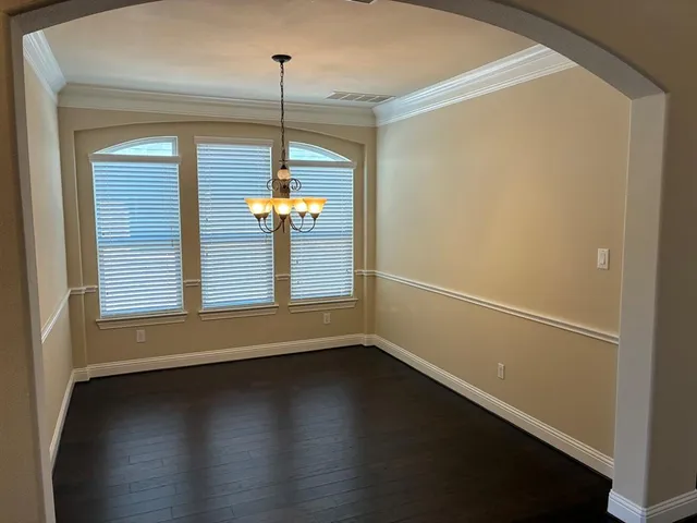 a view of a room that has wooden floor and a window