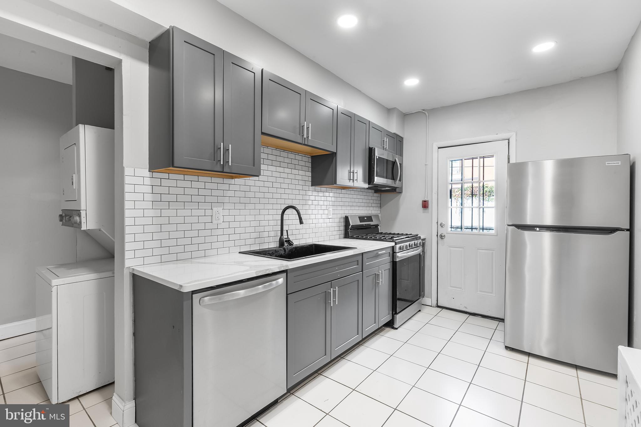 a kitchen with stainless steel appliances granite countertop a refrigerator sink and cabinets