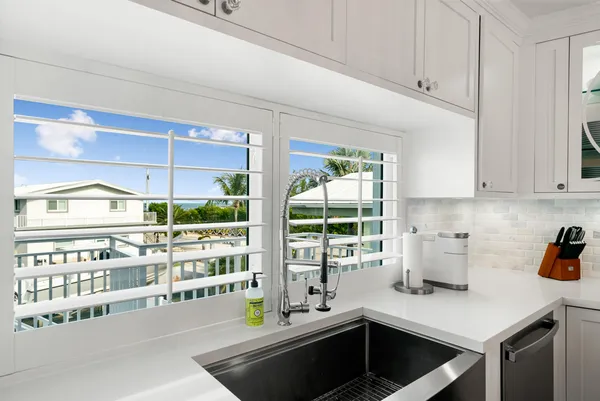 a kitchen that has a lot of cabinets in it and wooden floors