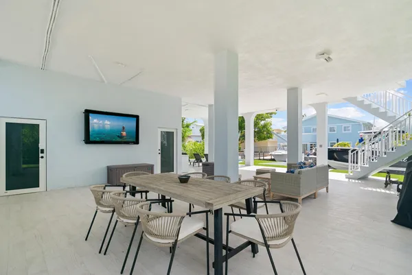 a view of a dining room with furniture a rug and a flat screen tv