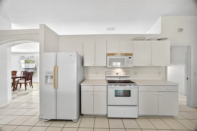 a kitchen with white cabinets and white appliances