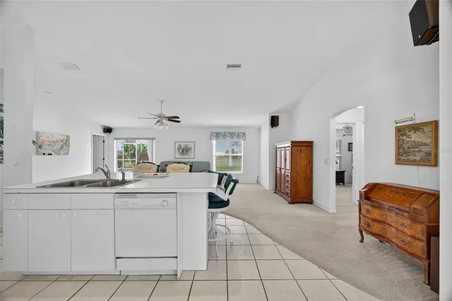 a kitchen with stainless steel appliances kitchen island granite countertop a refrigerator and a sink