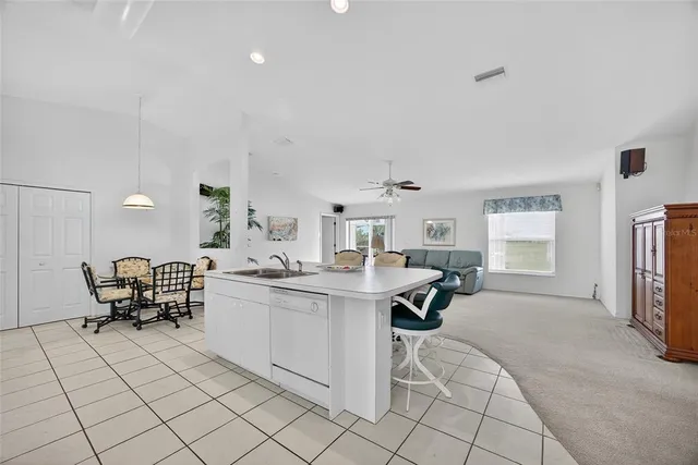 a kitchen with a sink and chairs