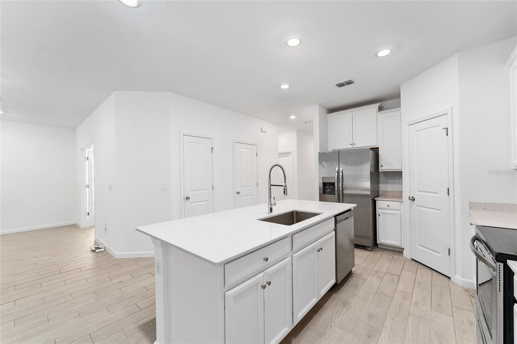 7755 Southwest 74th Loop Ocala, FL 34481 - Photo 12 of 66 a kitchen with white cabinets and stainless steel appliances