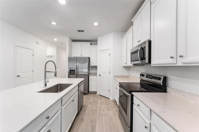 a kitchen with white cabinets and stainless steel appliances