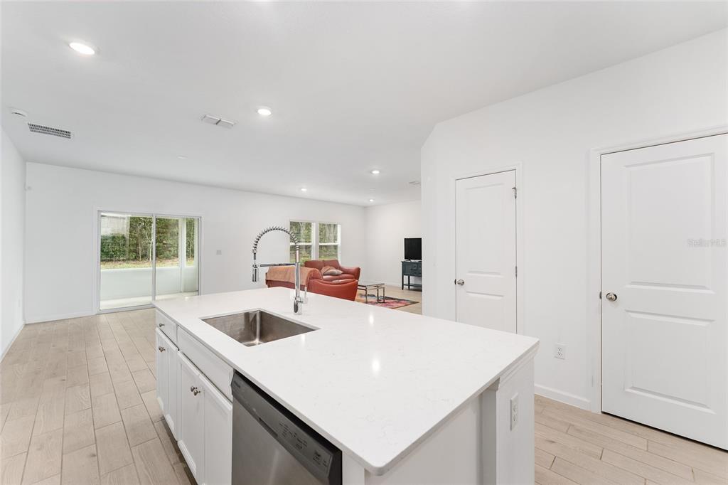 7755 Southwest 74th Loop Ocala, FL 34481 - Photo 14 of 66 a kitchen with kitchen island a sink dishwasher a stove and a refrigerator with wooden floor