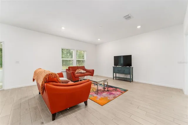 a living room with furniture a flat screen tv and a window