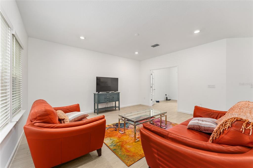 7755 Southwest 74th Loop Ocala, FL 34481 - Photo 20 of 66 a living room with furniture a flat screen tv and a window