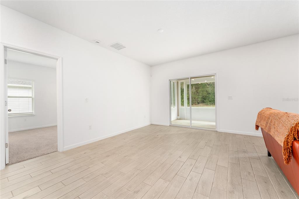 7755 Southwest 74th Loop Ocala, FL 34481 - Photo 22 of 66 an empty room with a window and a wooden floor