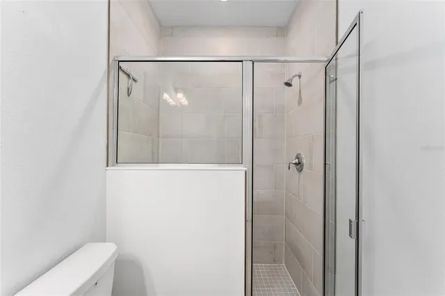 a white house that has a small yard and large trees