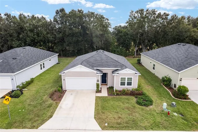 a aerial view of a house with a yard and large trees