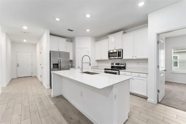 a kitchen with white cabinets and stainless steel appliances