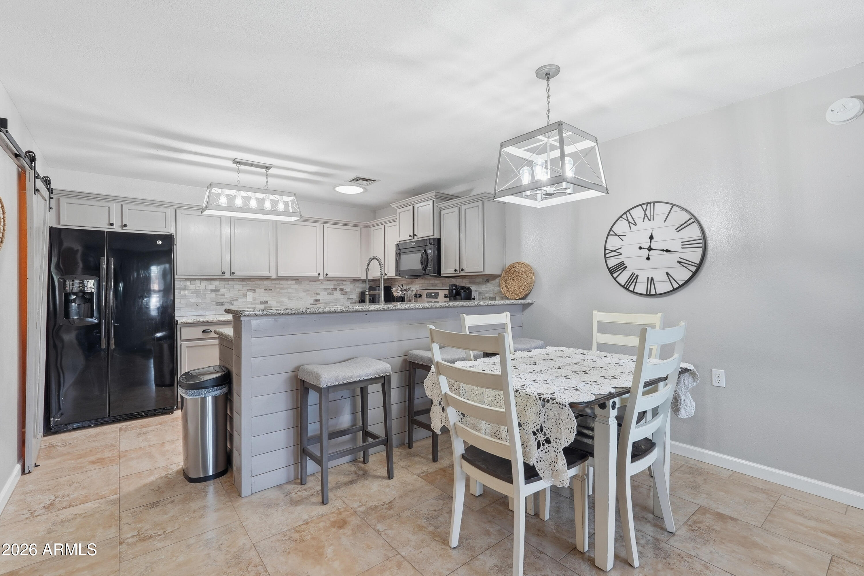 14300 West Bell Road, Unit 49 Surprise, AZ 85374 - Photo 4 of 19 a view of a dining room with furniture a chandelier and kitchen view
