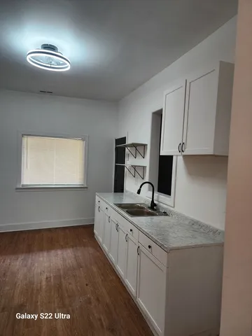 a kitchen with a sink cabinets and wooden floor