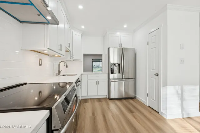 a kitchen with stainless steel appliances granite countertop a refrigerator sink and stove
