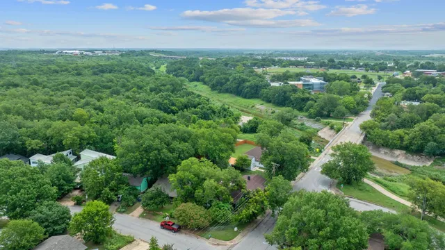 an aerial view of residential houses with outdoor space and trees