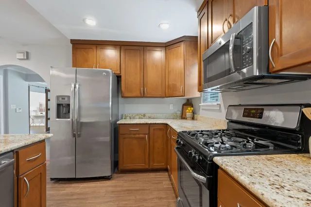 a kitchen with stainless steel appliances granite countertop a stove a refrigerator and a sink