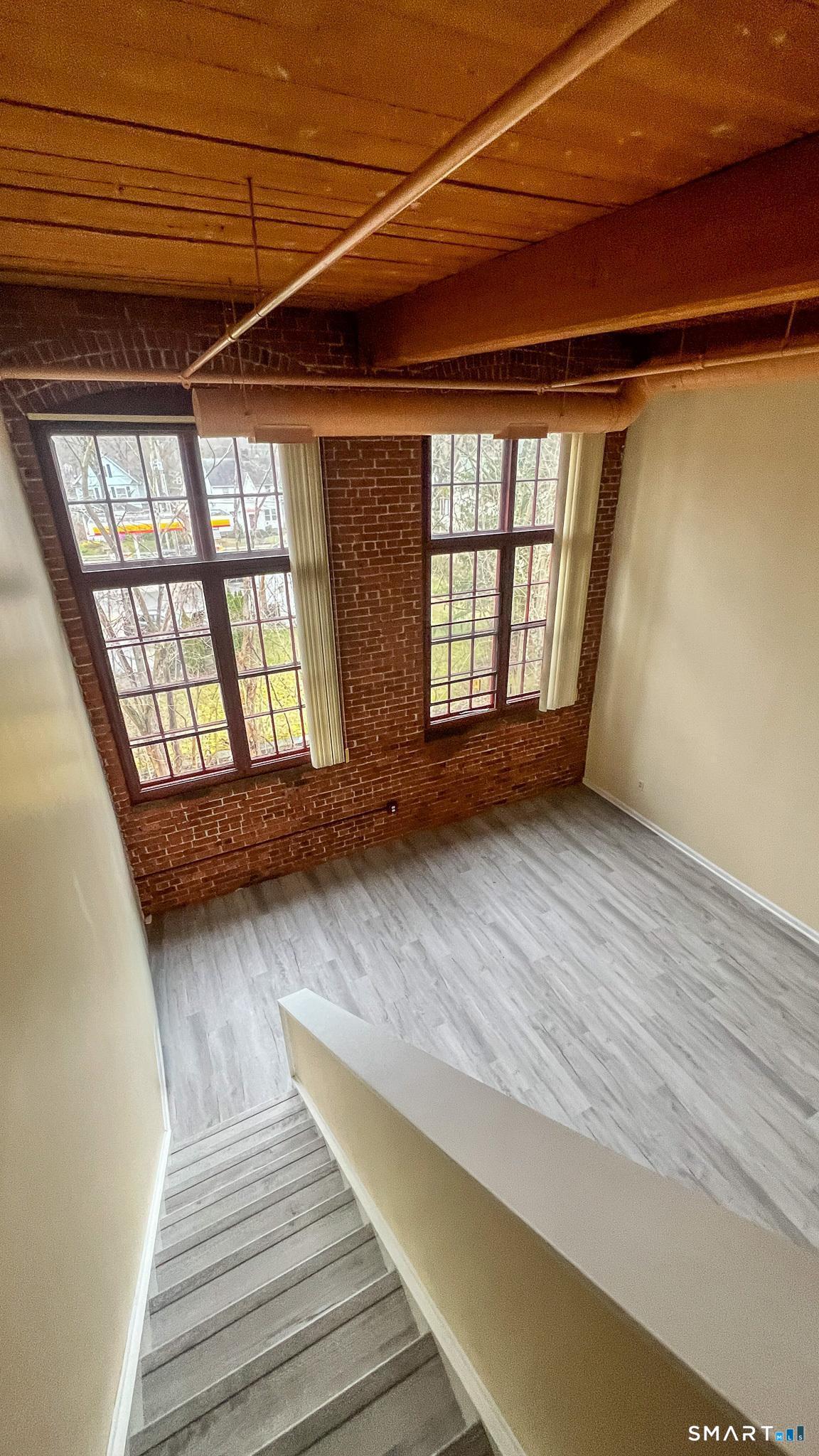 839 Main Street, Unit 68 Torrington, CT 06790 - Photo 13 of 20 a view of an empty room with wooden floor and a window