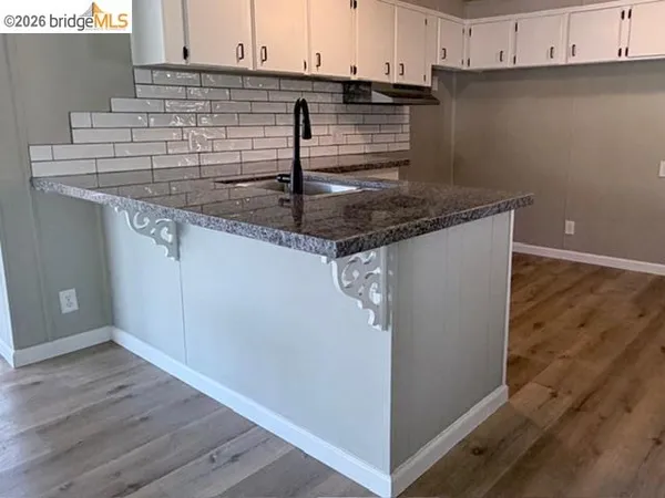 a kitchen with granite countertop a sink and a stove