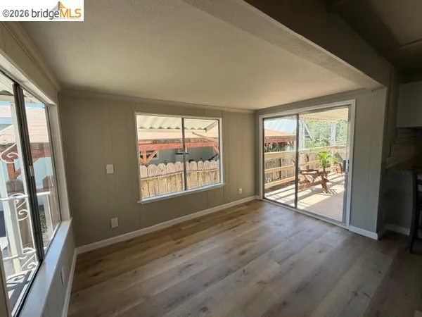 an empty room with wooden floor and windows